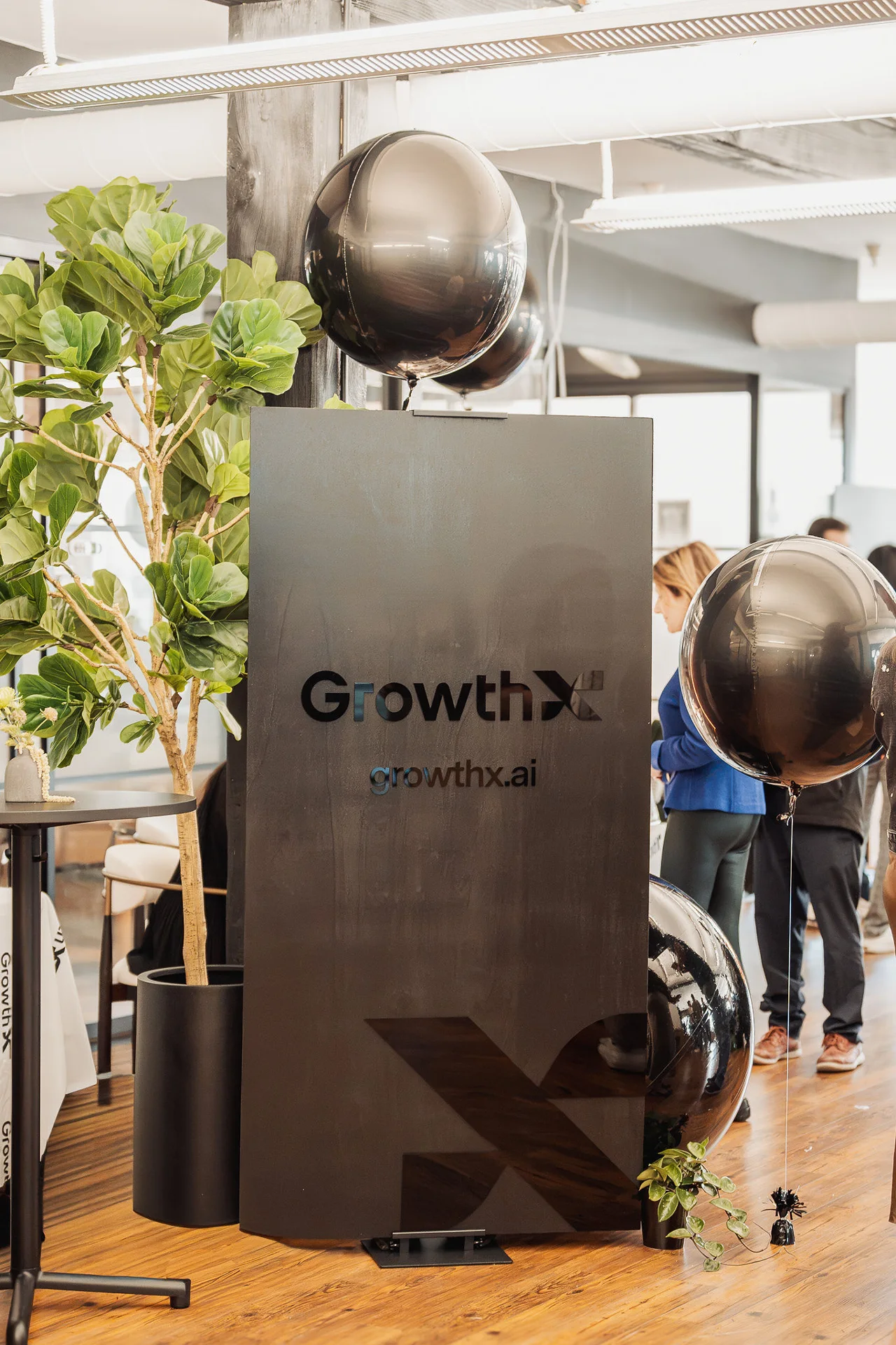 GrowthX welcome sign with black balloons and greenery at GrowthX Launch Party