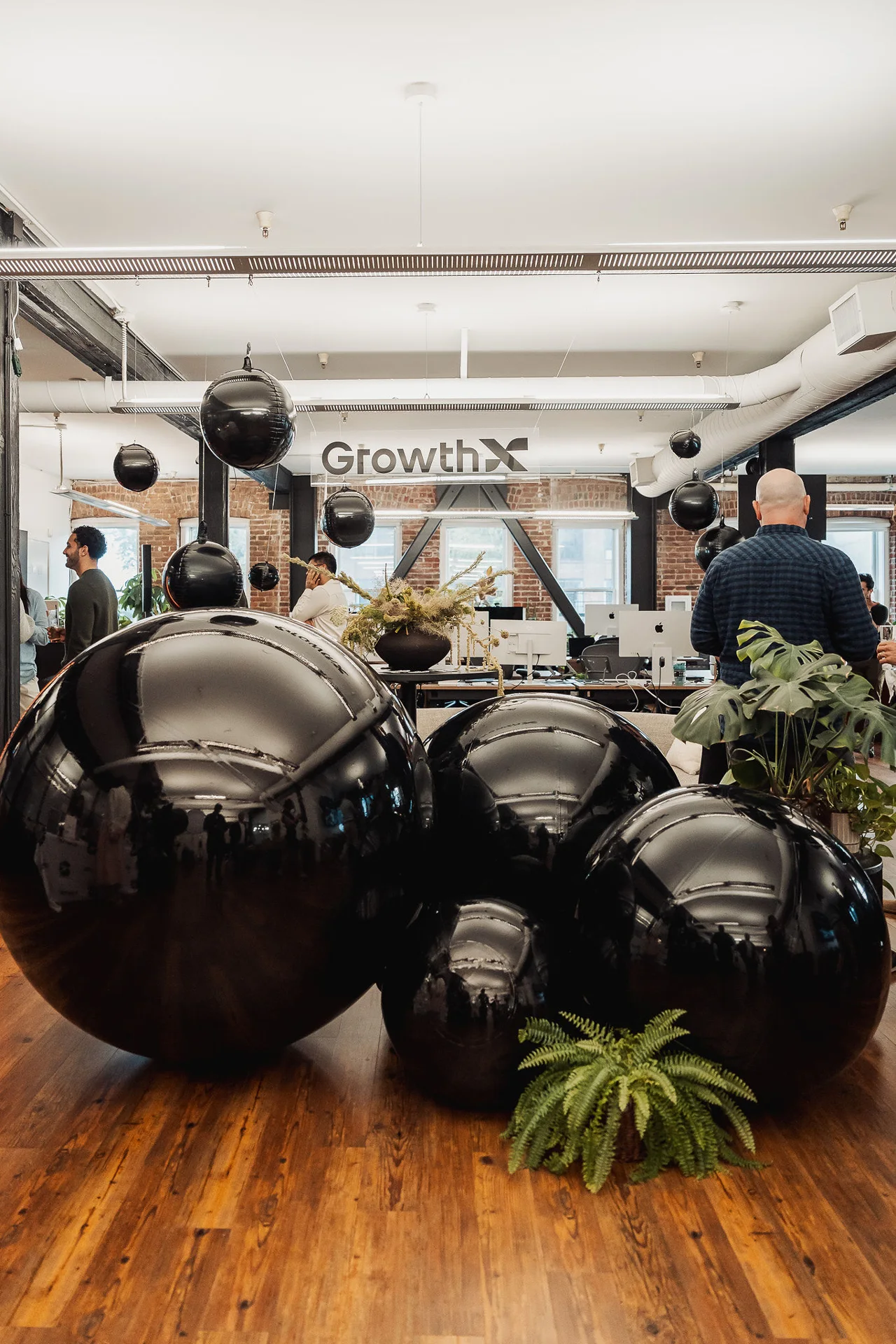 Oversized black balloon installation across the office floor at GrowthX Launch Party