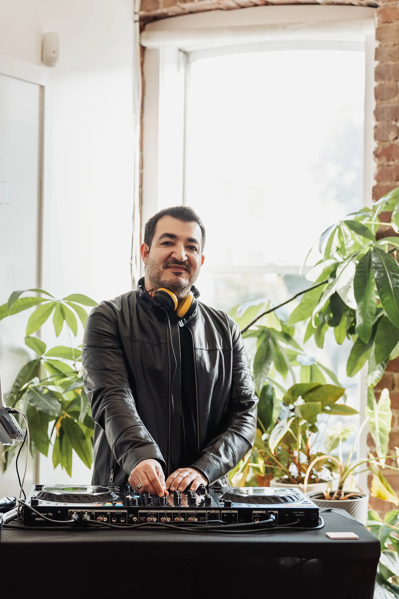 DJ performing beside office windows and plants at GrowthX Launch Party