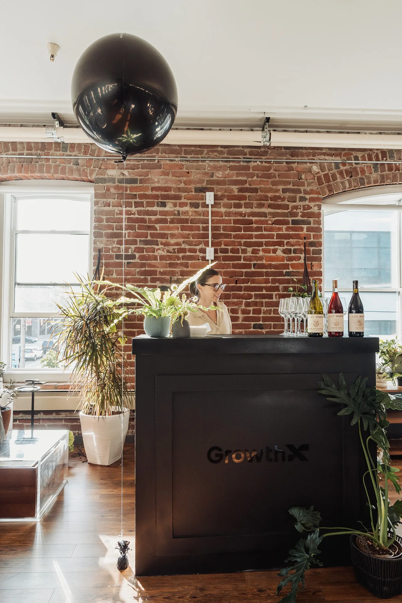 Cocktail bar with hanging black balloons at GrowthX Launch Party