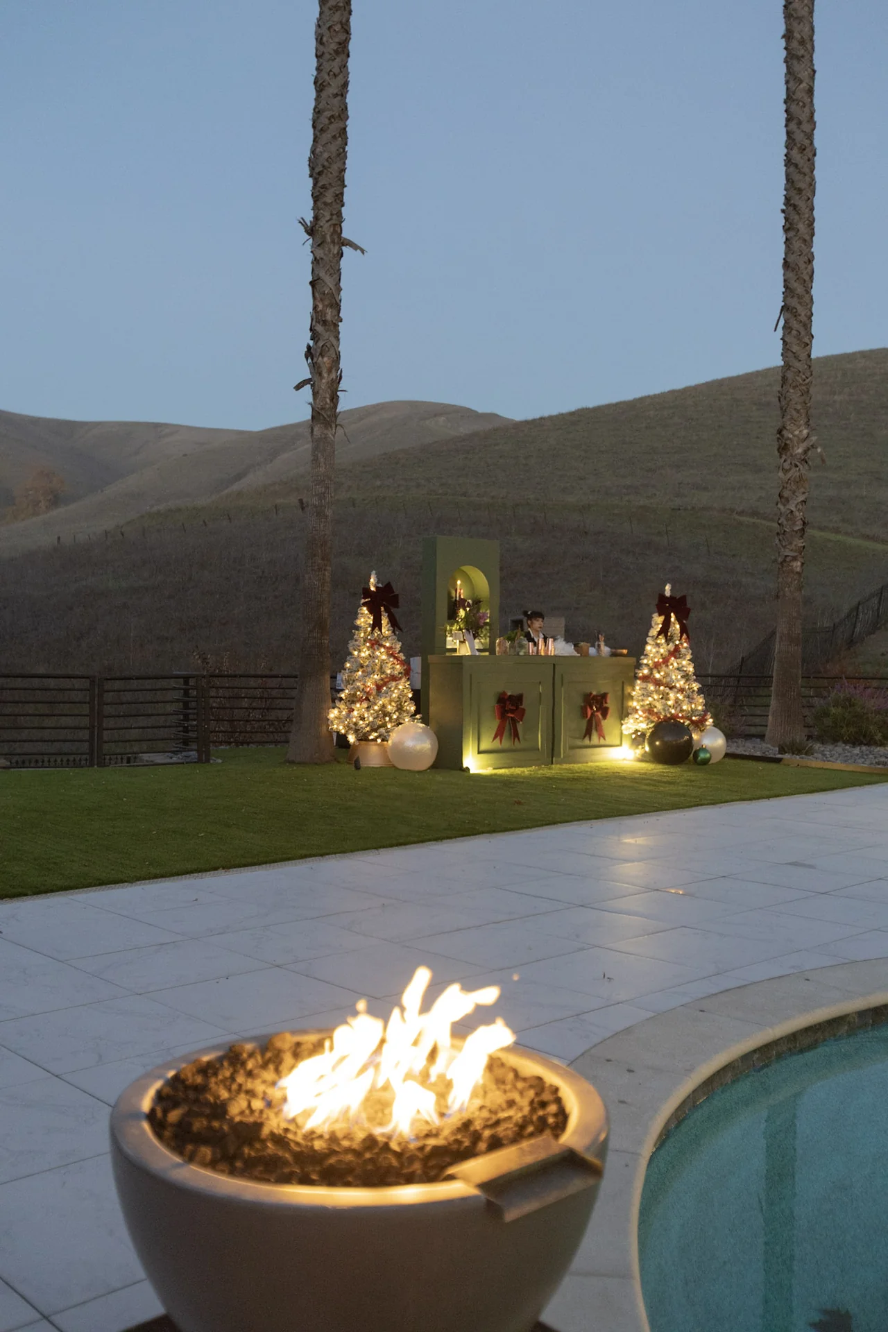 Poolside fire feature at dusk at M&E Company Holiday Party