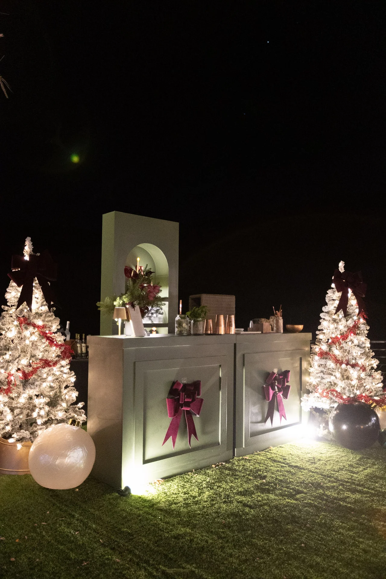 Holiday trees and gifts illuminated at night at M&E Company Holiday Party