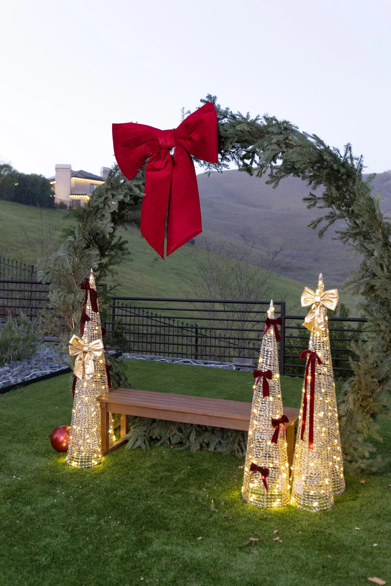 Holiday wreath with red bow and gold trees at M&E Company Holiday Party