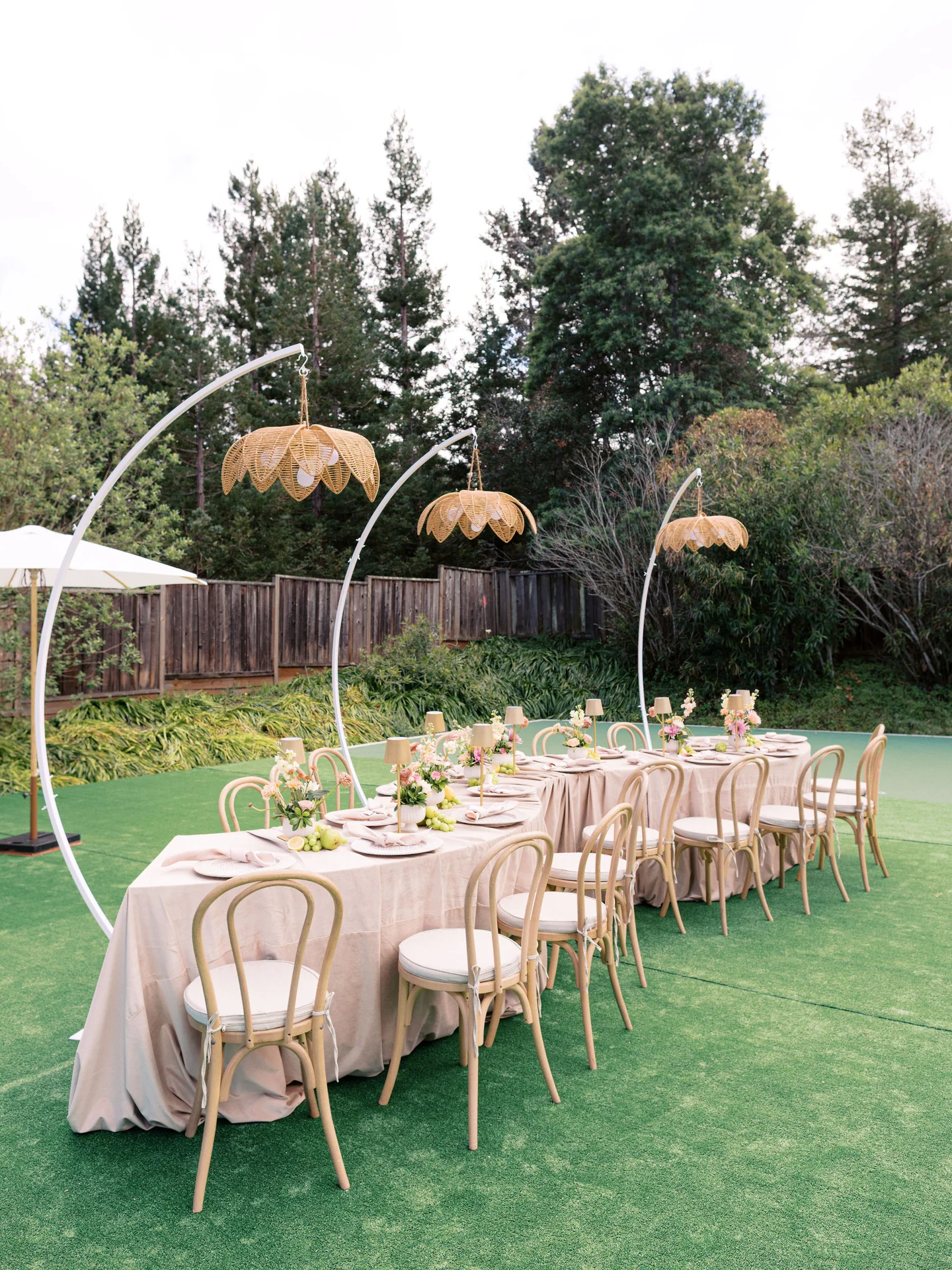 Long garden table beneath woven pendant lights at Spring Soiree